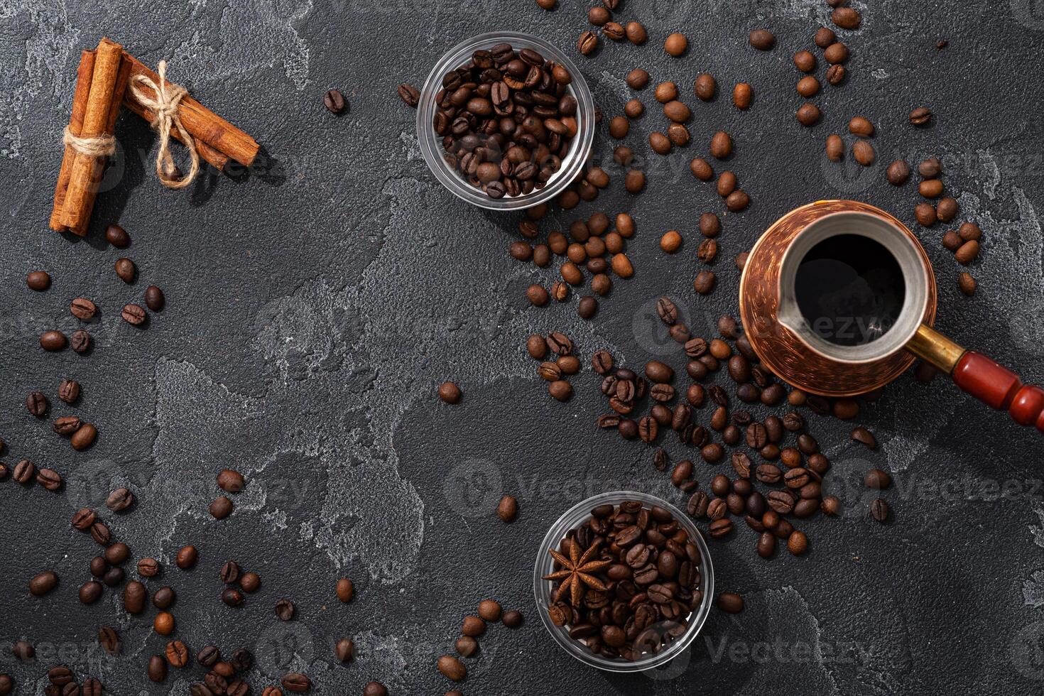 Coffee beans, cinnamon sticks and star anise on dark background top view photo