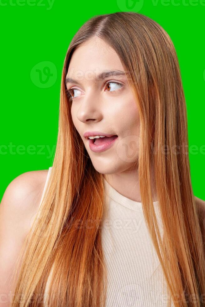 Young Woman With Surprised Expression in Front of Green Screen photo