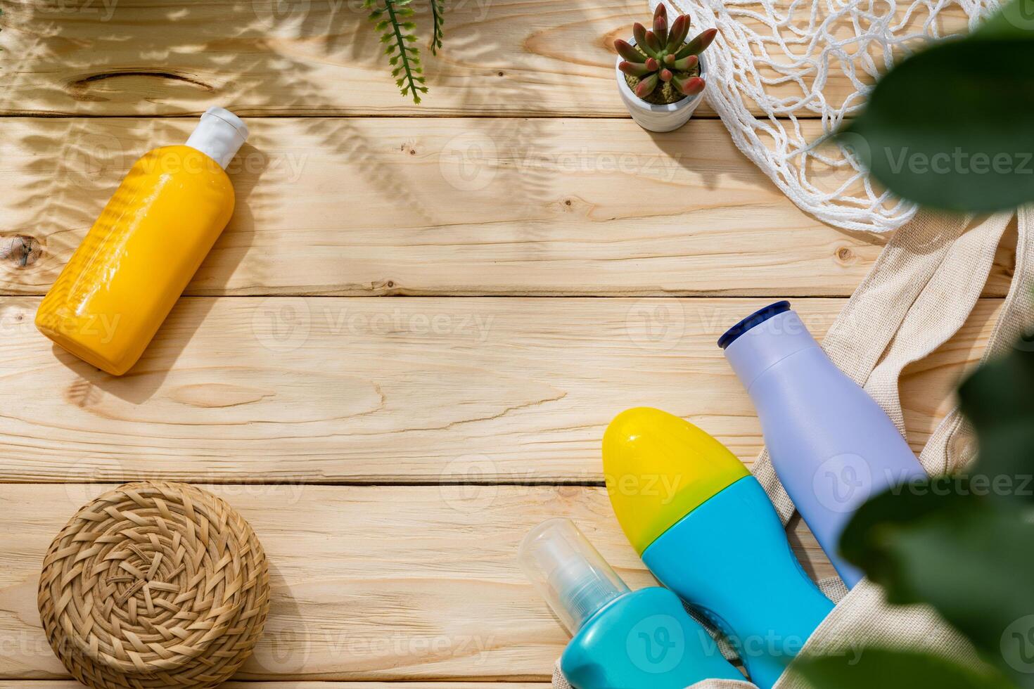 Sunscreen cream bottles in beach bag on wooden background photo