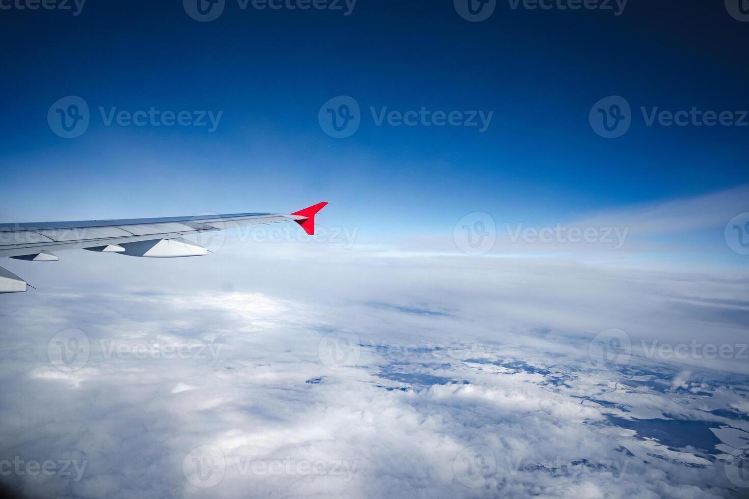 Aircraft wing above beautiful clouds and blue sky photo