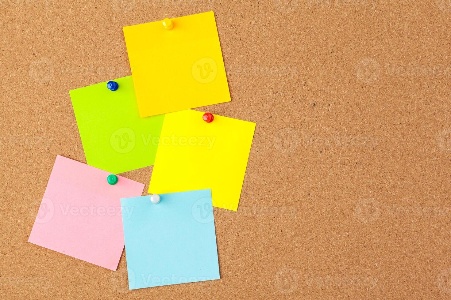 Cork board with several colorful blank notes with pins photo
