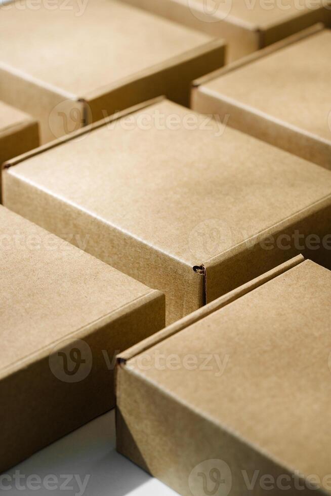 Brown cardboard boxes arranged on a neutral background in a warehouse setting during daylight hours photo
