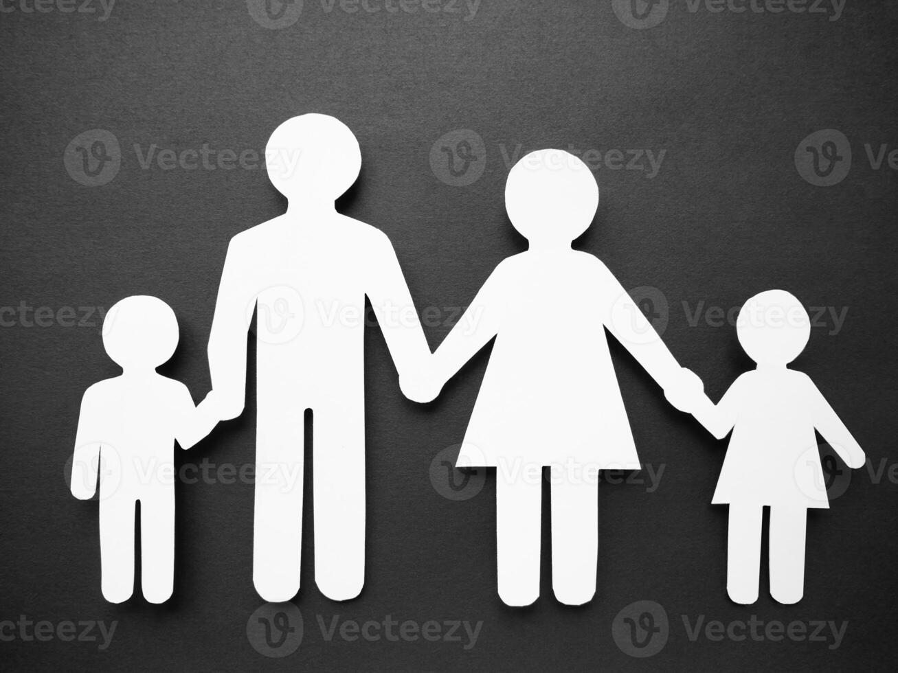Symbol of a man made of white paper on a black background. The concept of the family. Mom, dad, daughter and son. photo