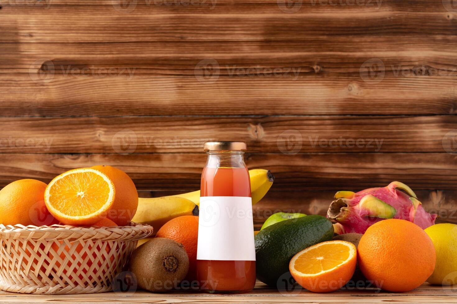 Fruit drink in glass bottle and frsh fruits on wooden background photo