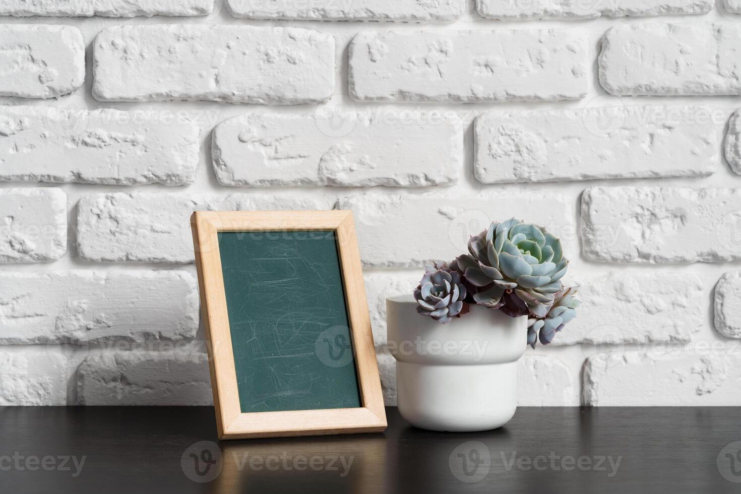 Wooden picture frame on a table with cactus photo