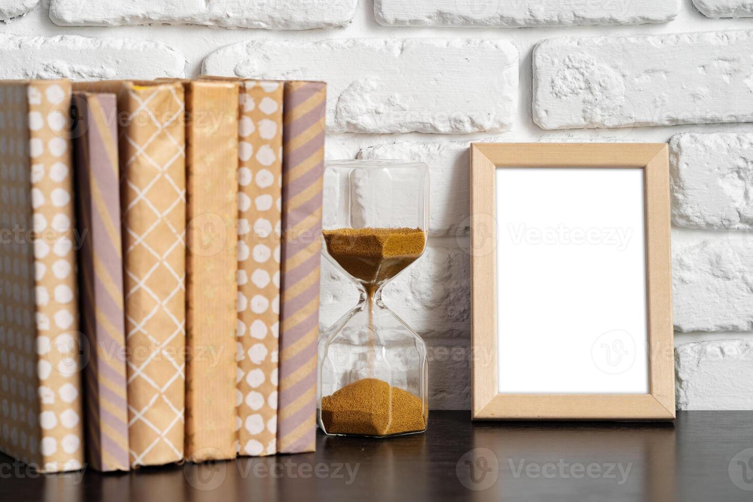 Books with picture frame on wooden table photo