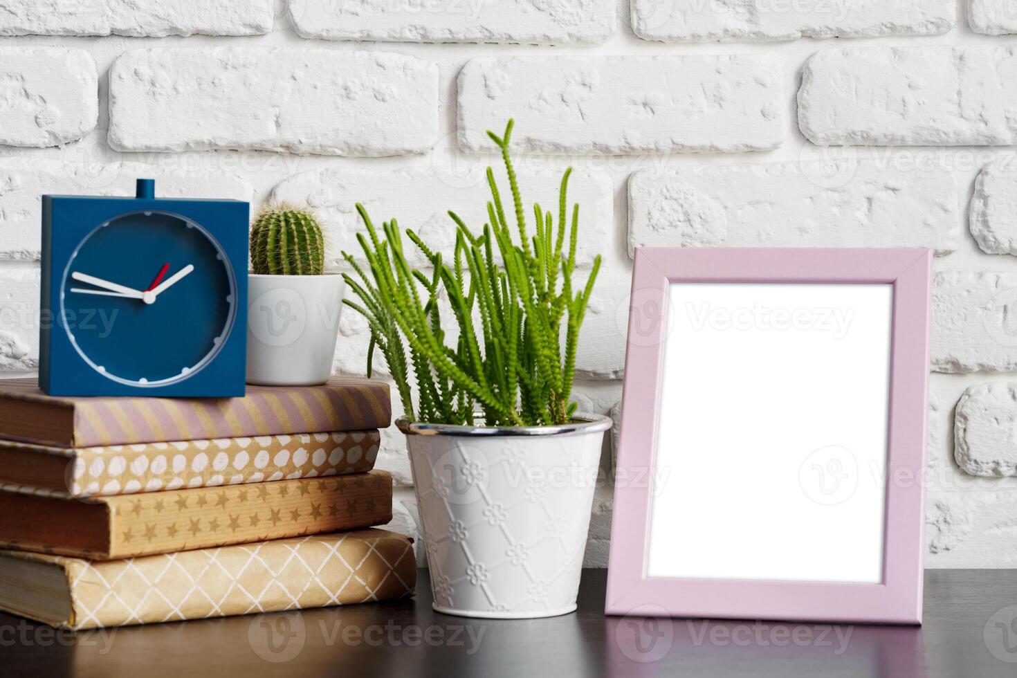 Books with picture frame on wooden table photo