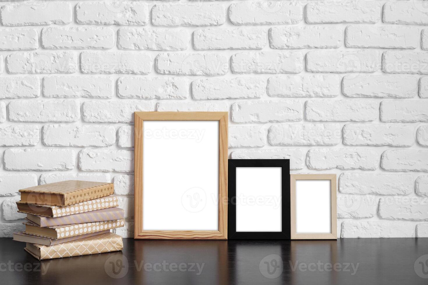 Books with picture frame on wooden table photo