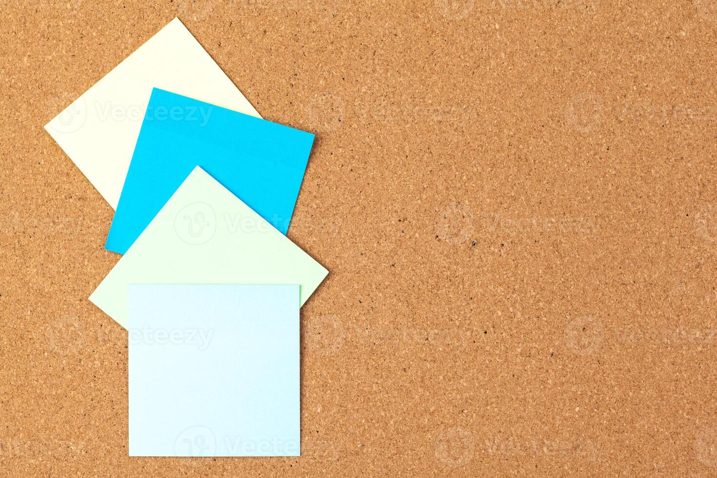 Cork board with several colorful blank notes with pins photo