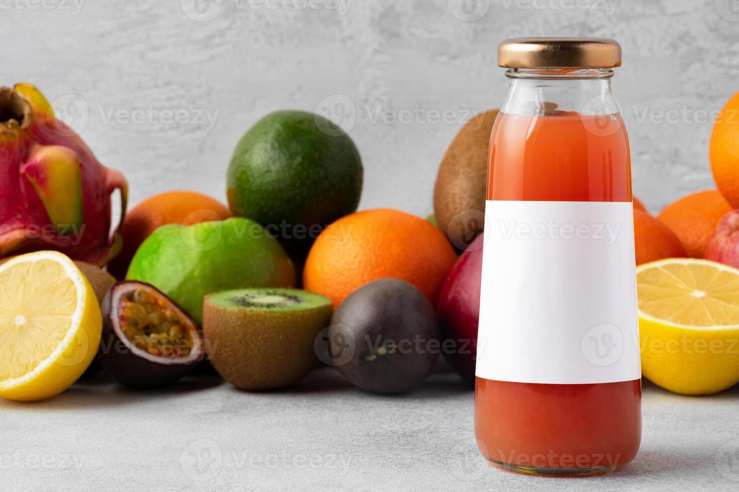 Various fruits and freshly squeezed fruits juice in bottle on gray background photo