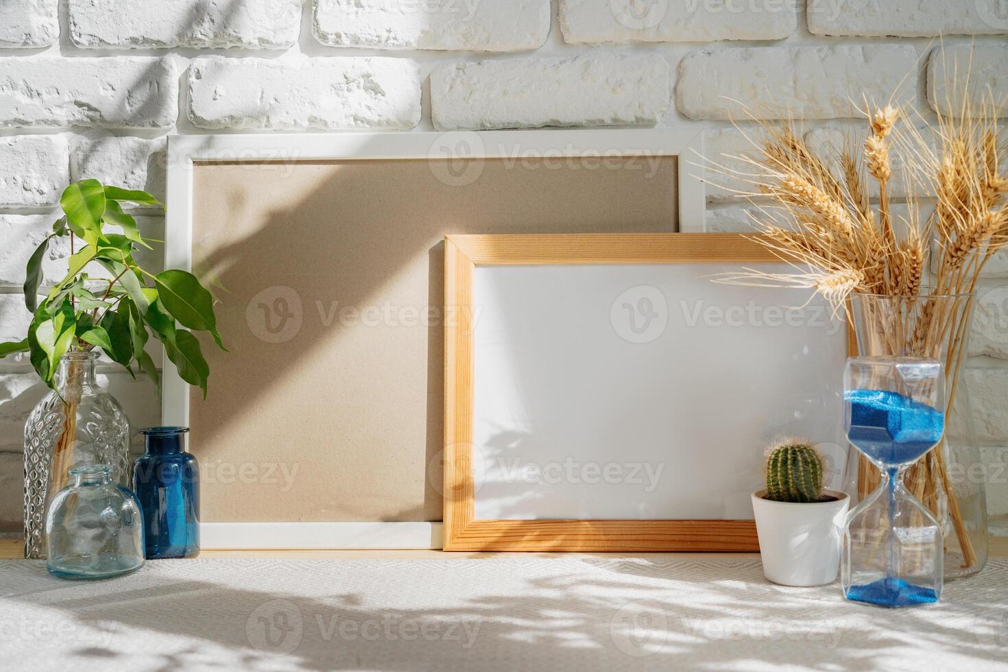 Photo frames on a brick wall background on the table with wheat ears in vase
