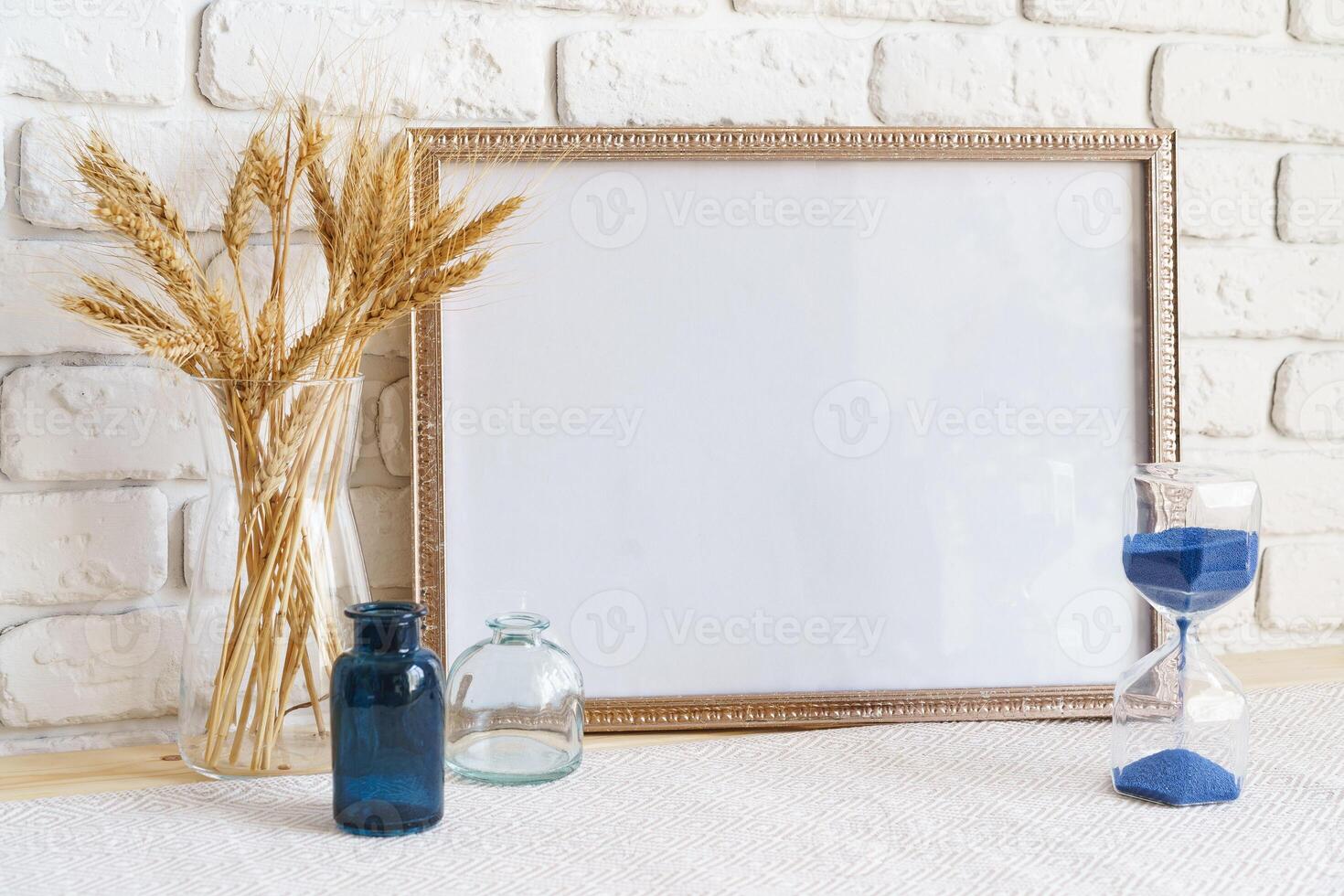 Mockup with a frame and dry flowers in a vase on a white table photo