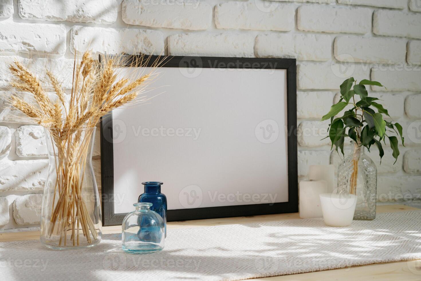 Mockup with a frame and dry flowers in a vase on a white table photo