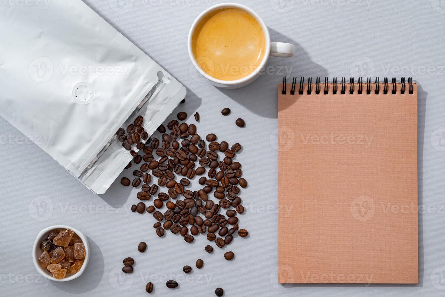 Cup of coffee with notebook on gray background top view photo