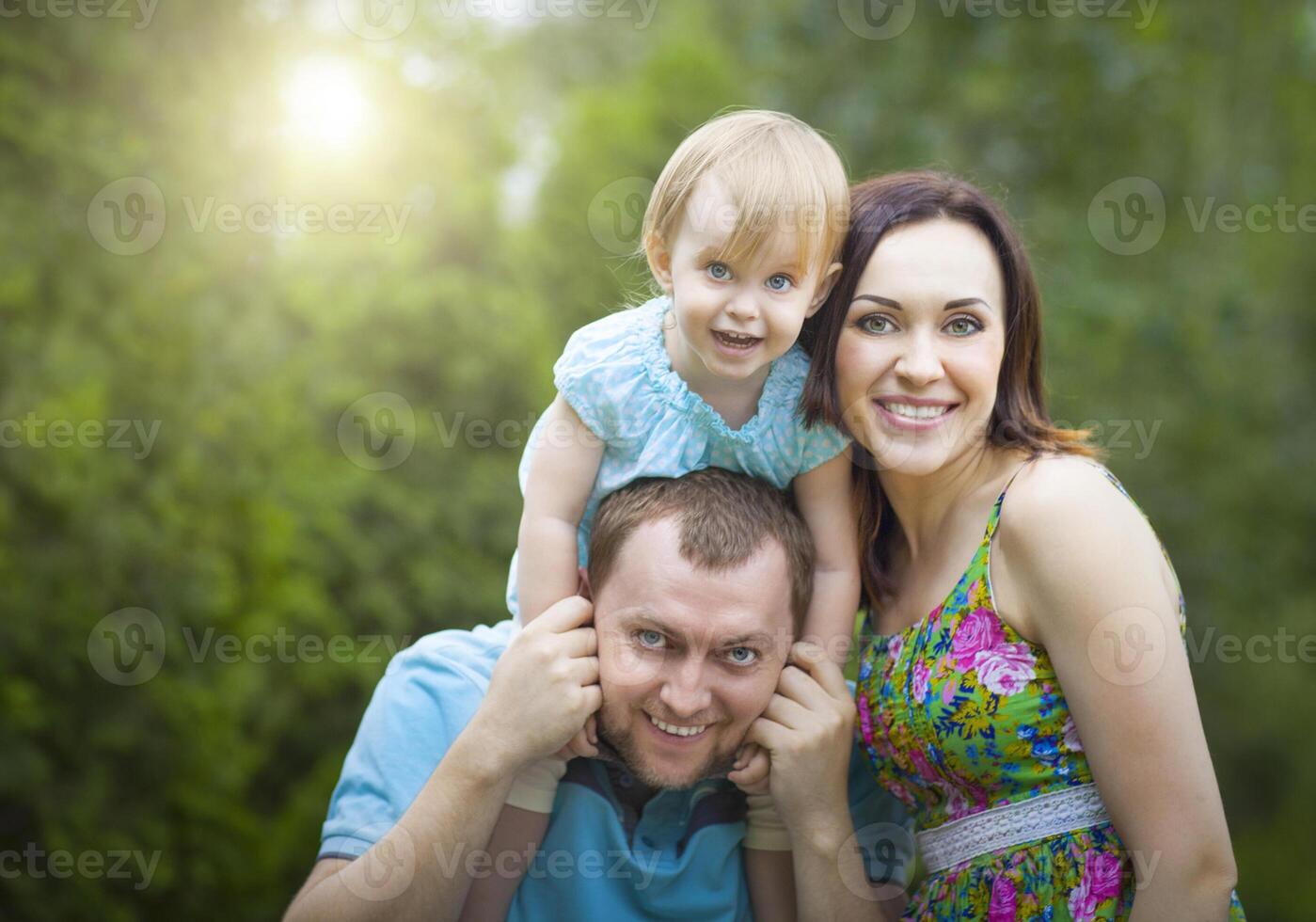 Happy young family with baby girl spending time outdoor photo