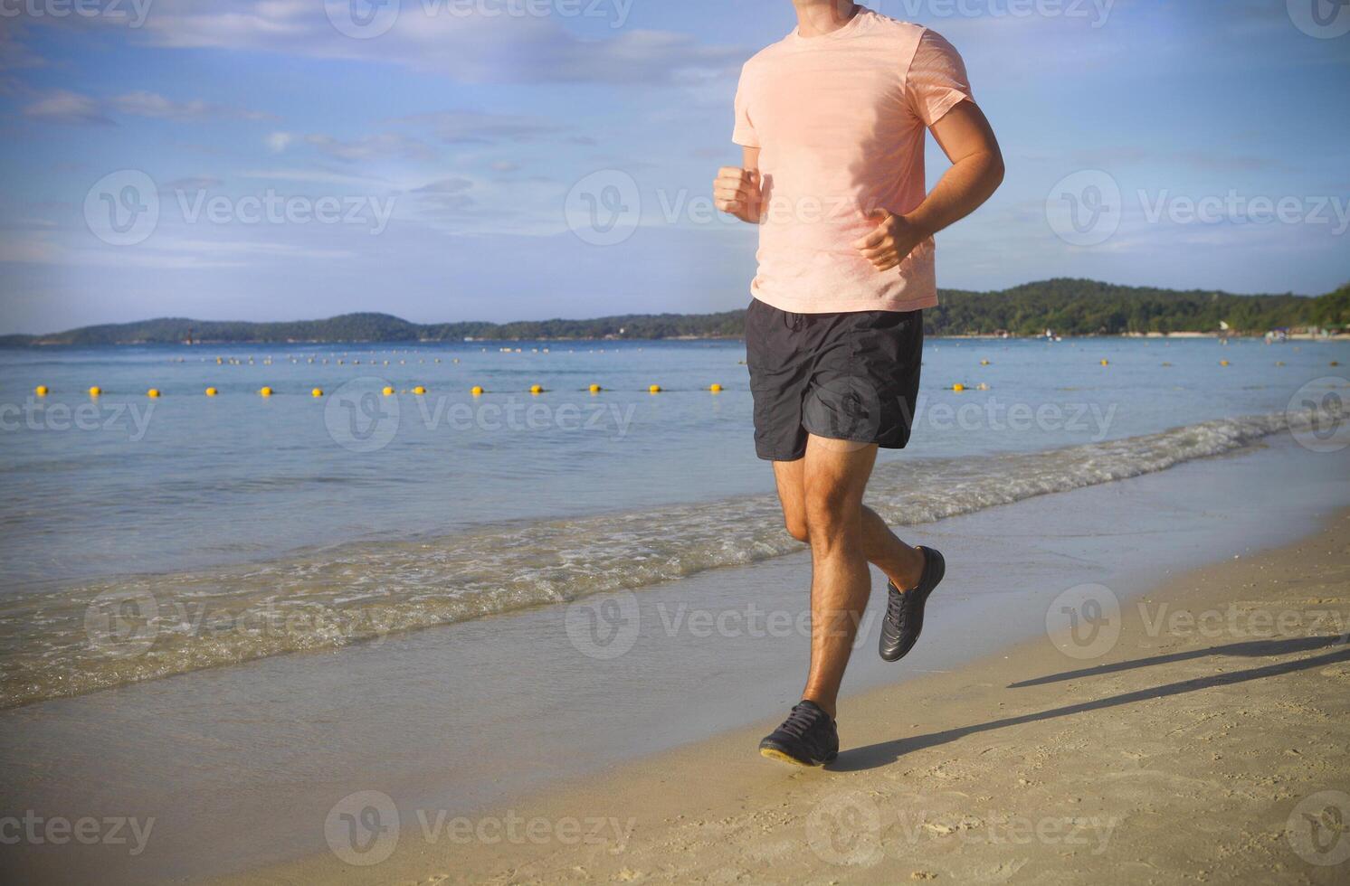 Man running on the beach at sunrise photo