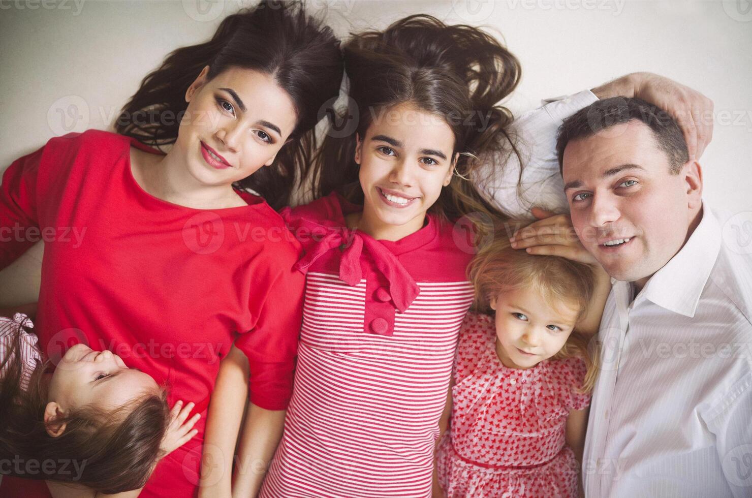Happy young family with kids lying on a floor photo