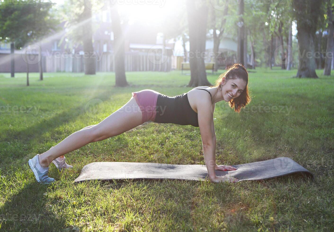 Stretching woman in outdoor exercise smiling happy doing stretches after running photo