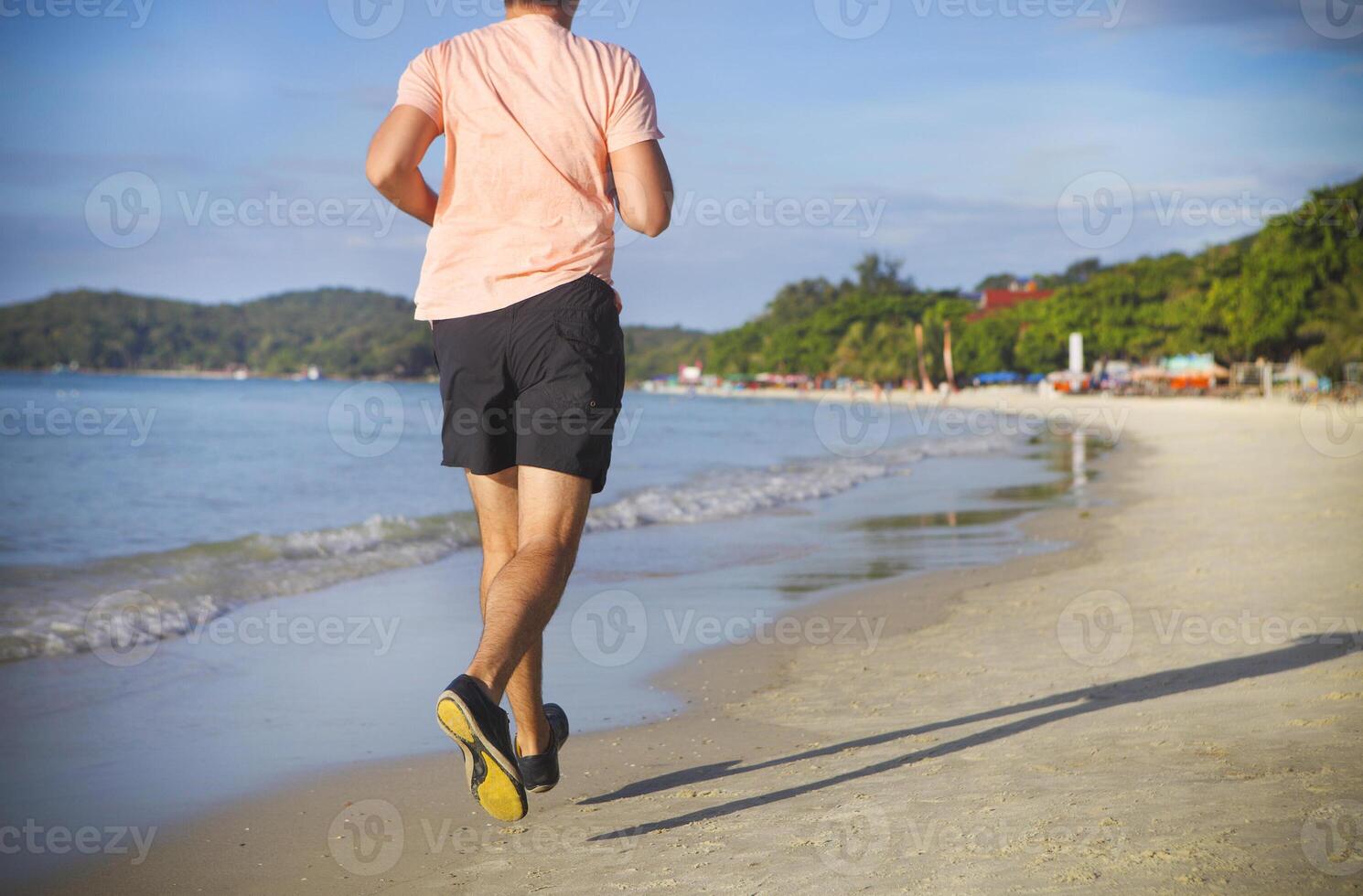 Man running on the beach at sunrise photo