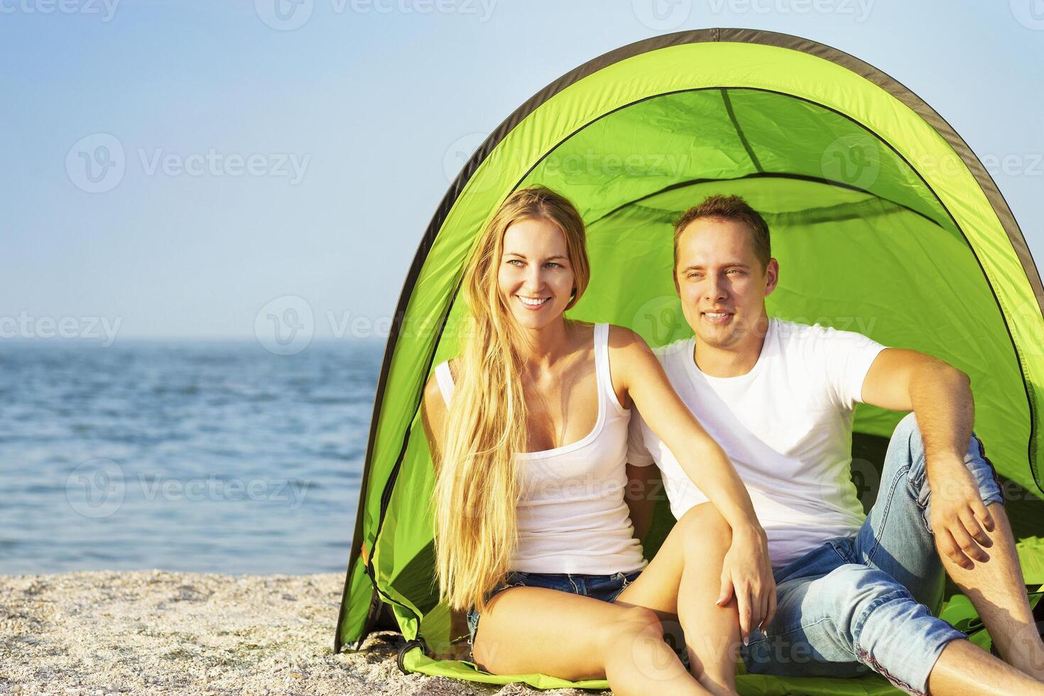 Happy young couple camping on the beach photo