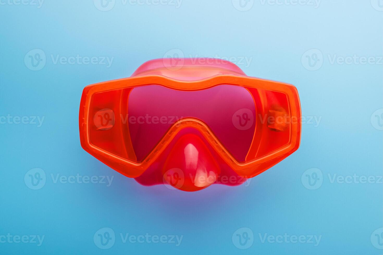 Red swimming mask on a blue background. Mask for diving under water photo