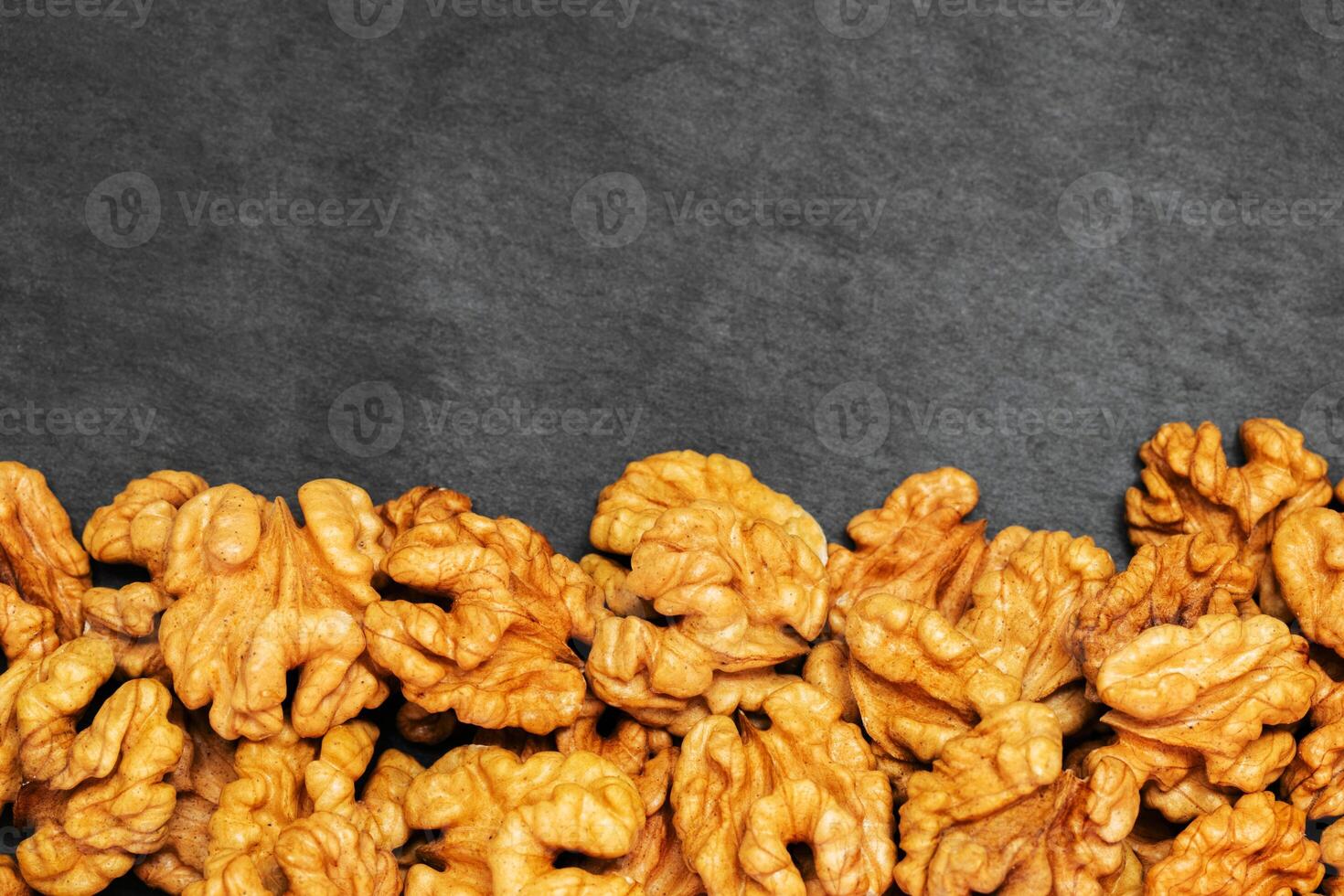 Walnuts. Walnut kernels on dark stone table. Top view photo