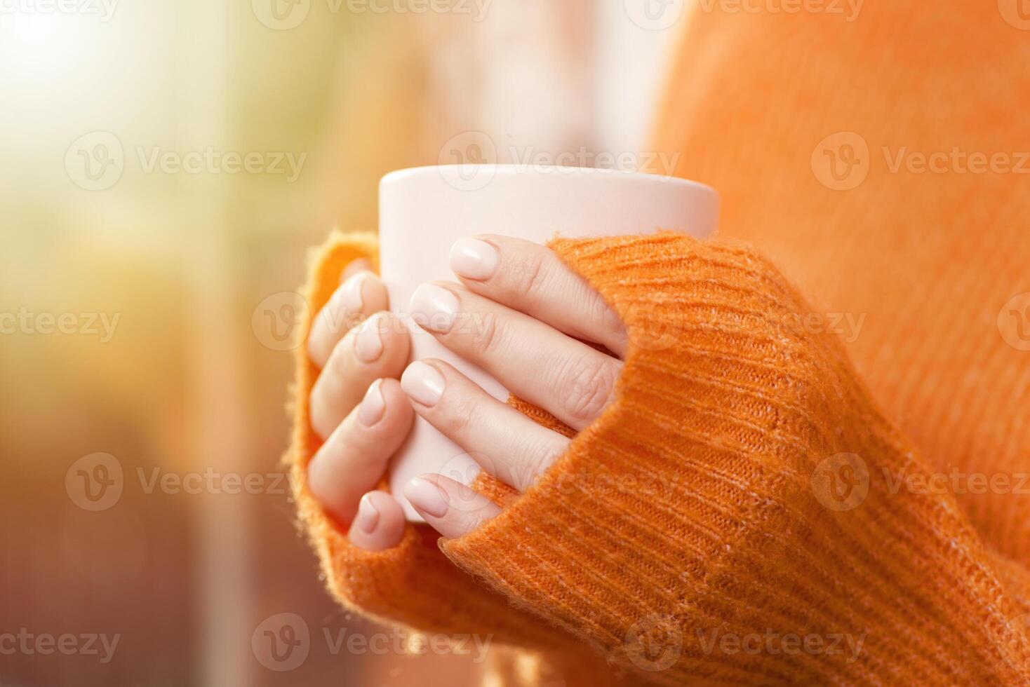 A woman drinks coffee at home with the sunrise through the window photo