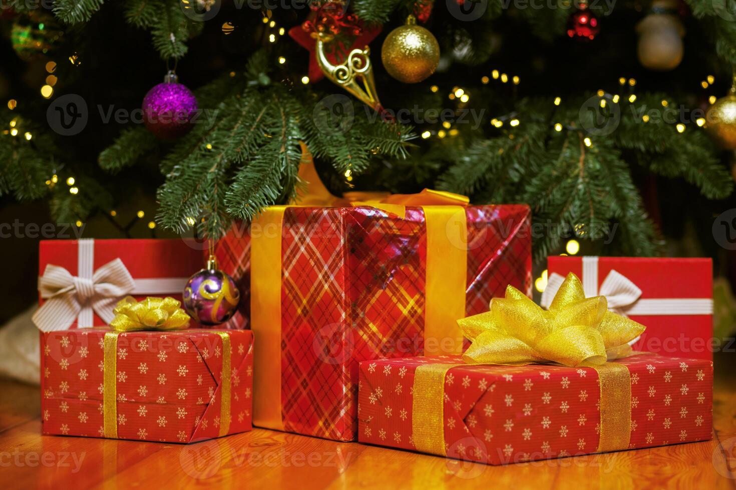 Pile of Christmas gift boxes on the floor under beautiful Christmas tree photo