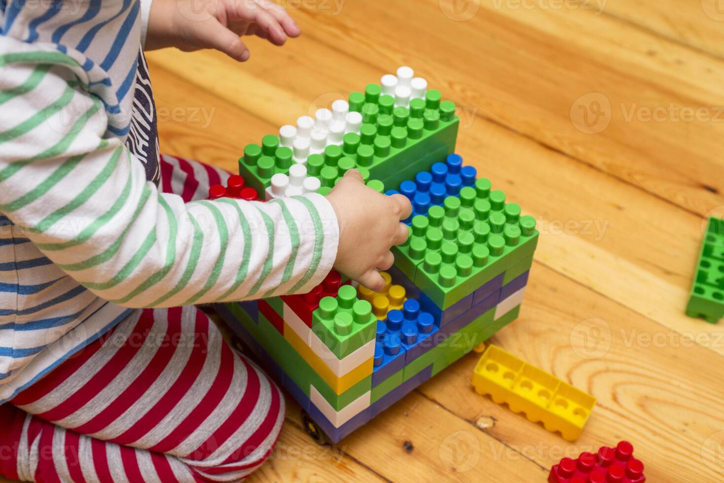 A child is playing with toy building blocks photo