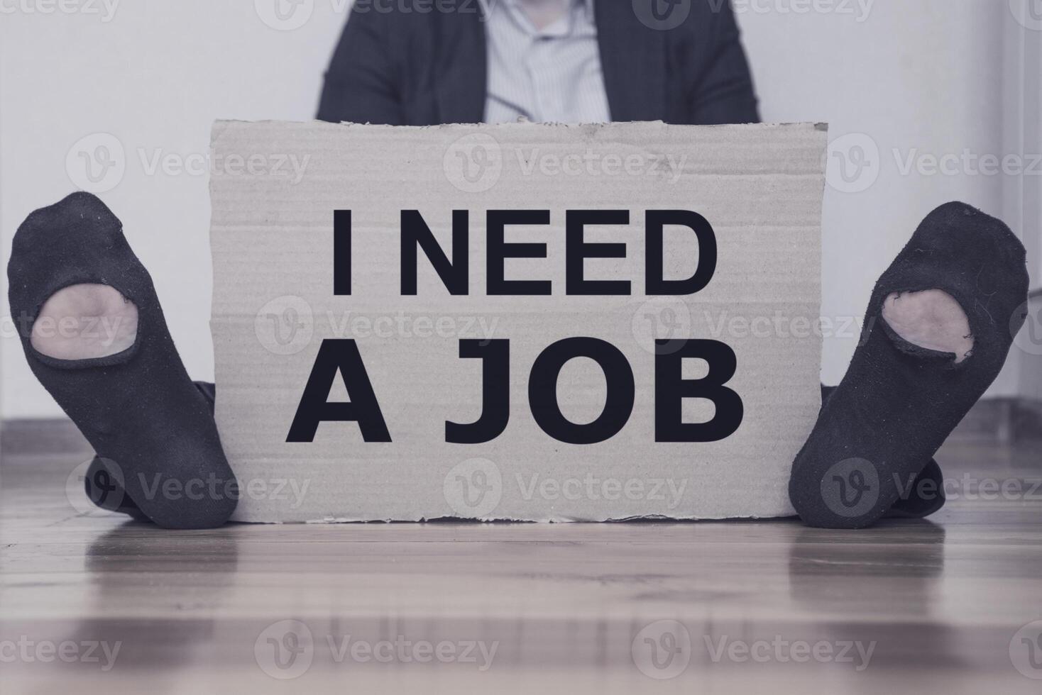 A man holding a cardboard with an inscription I NEED A JOB. photo