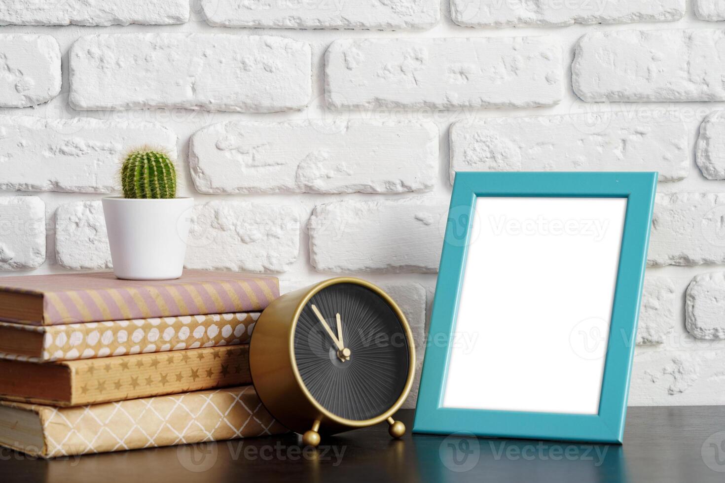 Books with picture frame on wooden table photo