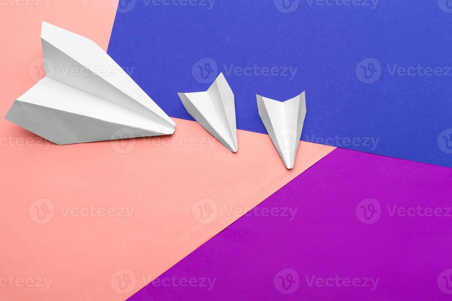 white paper airplane on a color block paper background photo