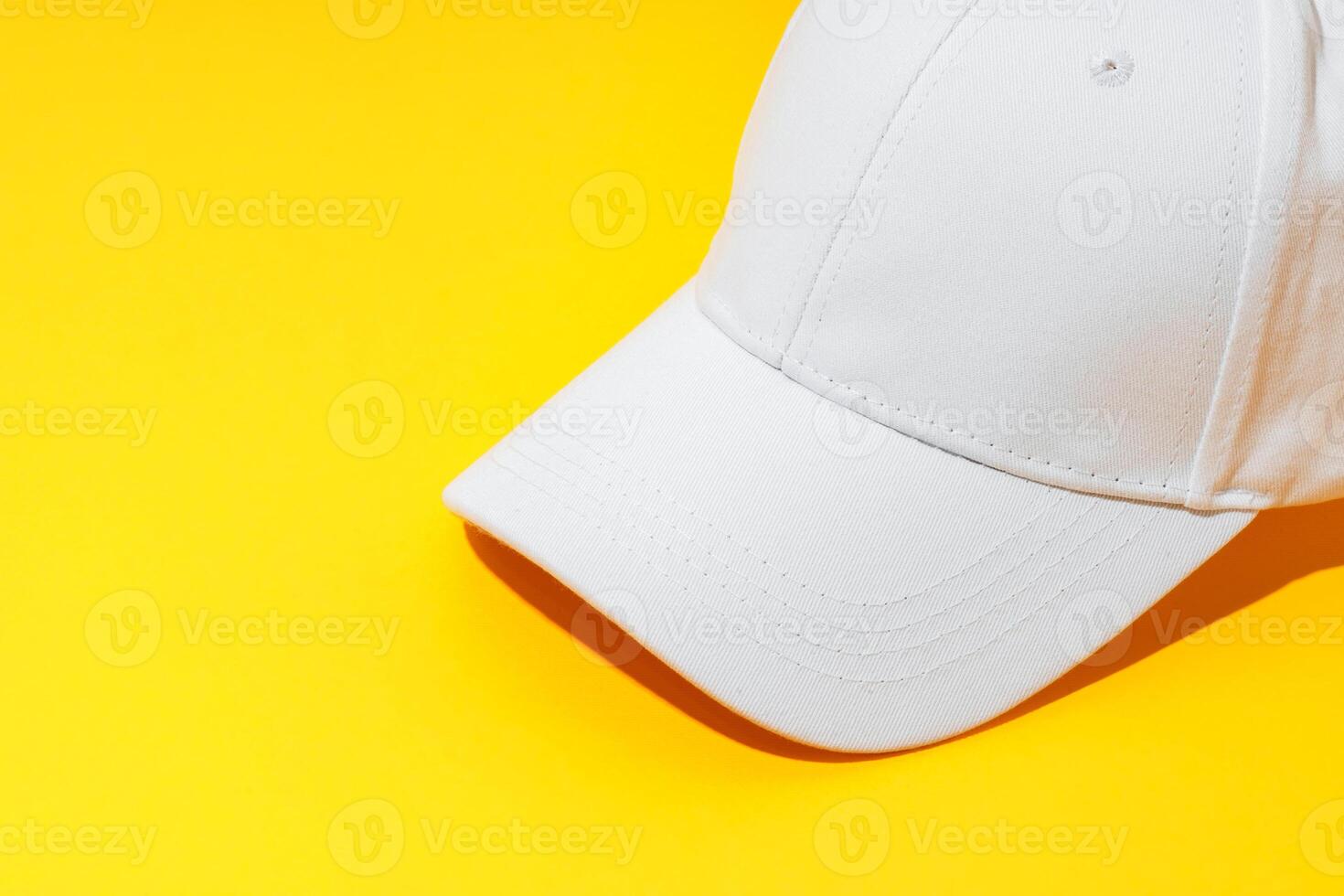 Baseball hat against yellow background in studio photo