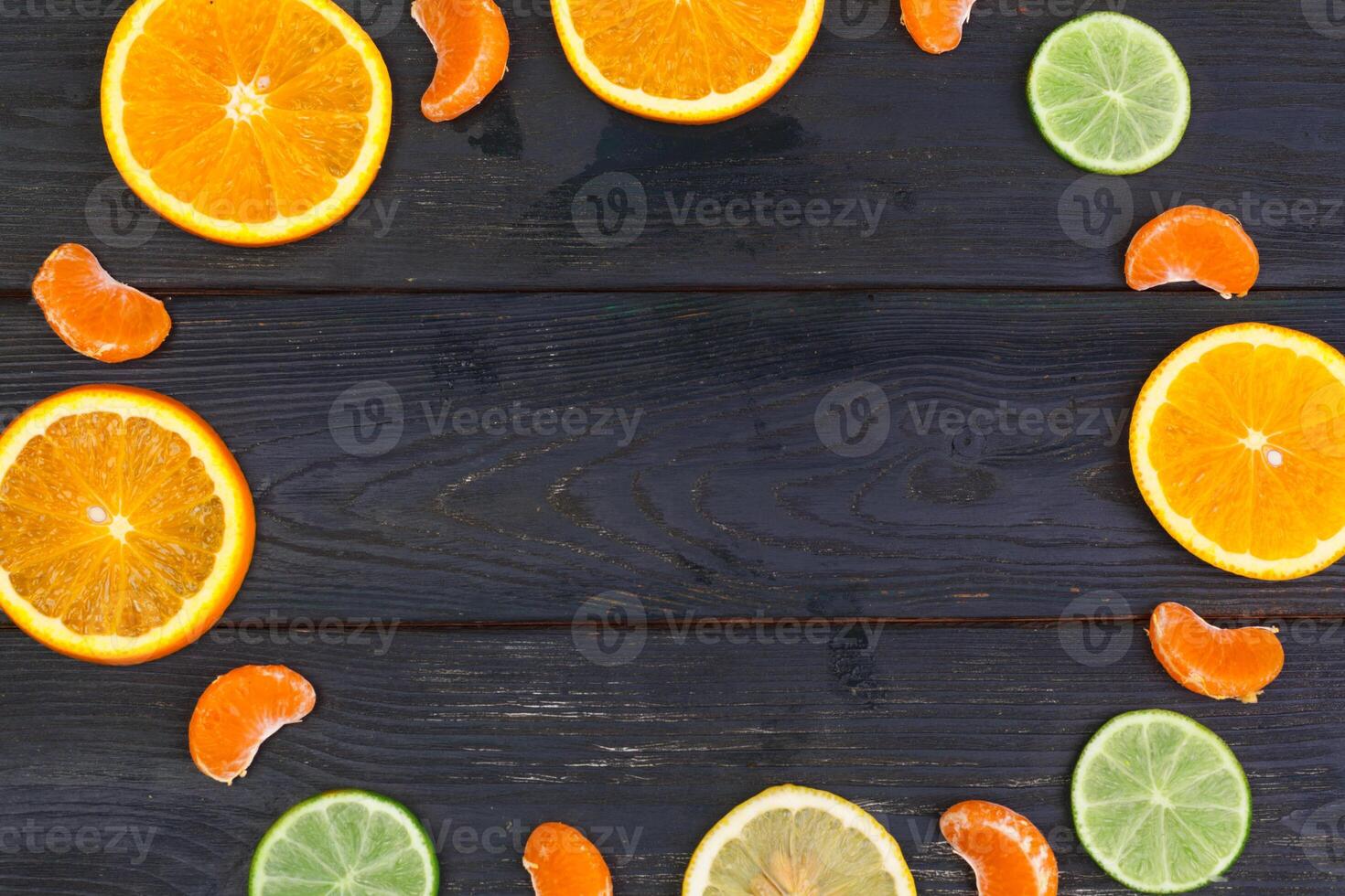 Bright composition of citrus fruits on black wooden background photo