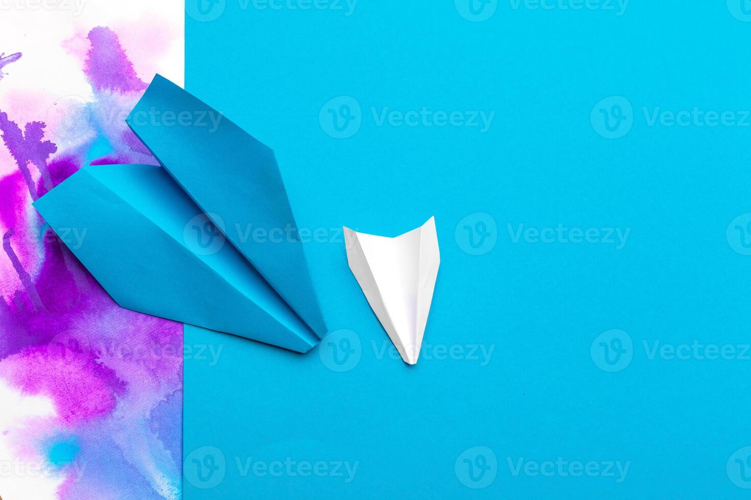 white paper airplane on a color block paper background photo