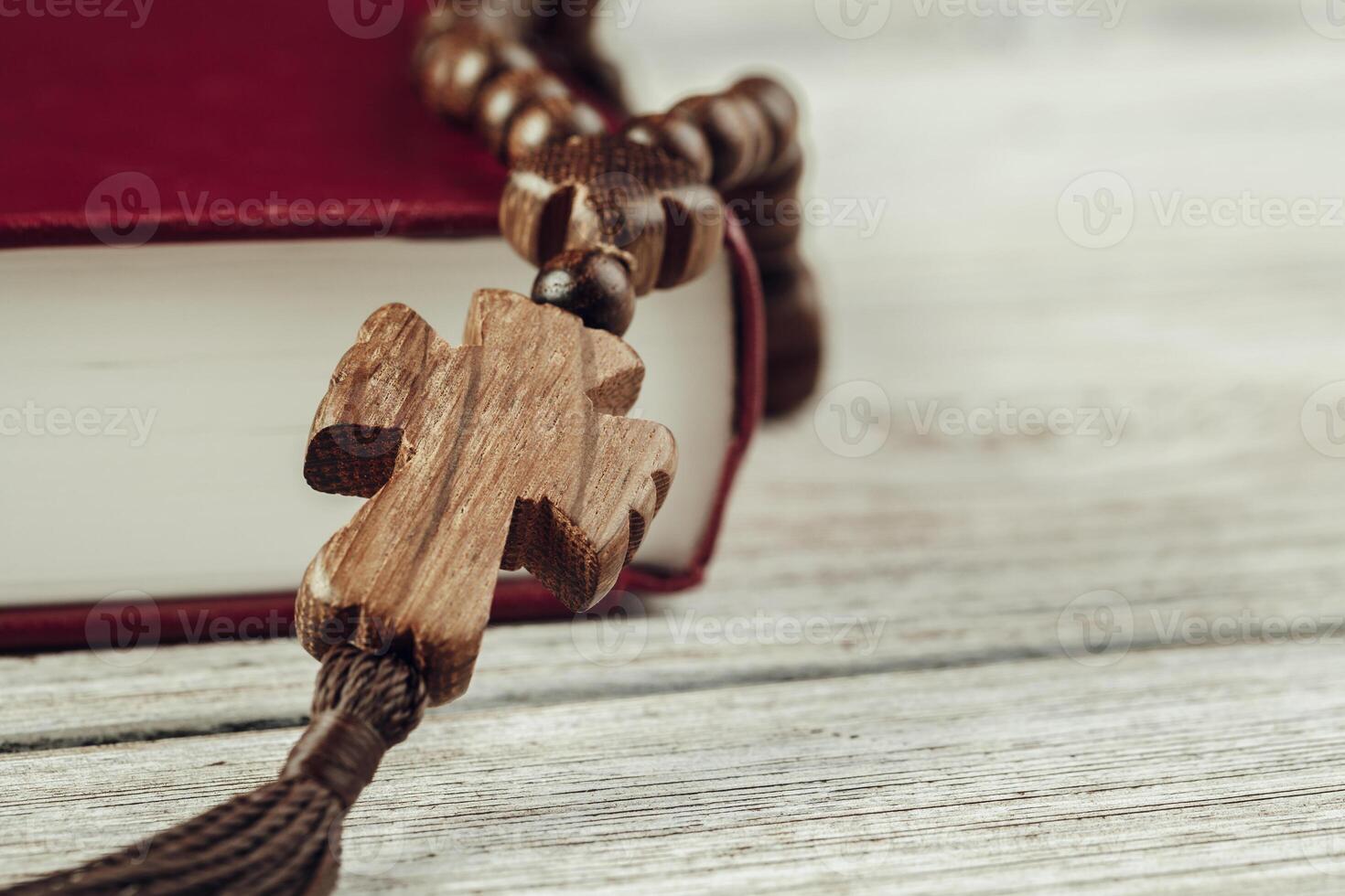 Bible and a crucifix on an old wooden table. Religion concept. photo