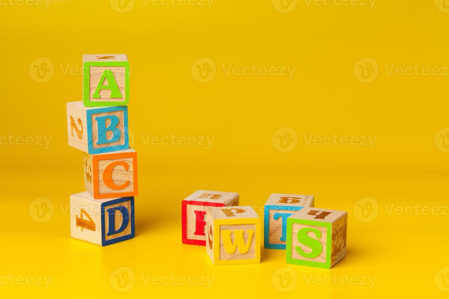 Colorful wooden blocks with letters on a yellow color background photo