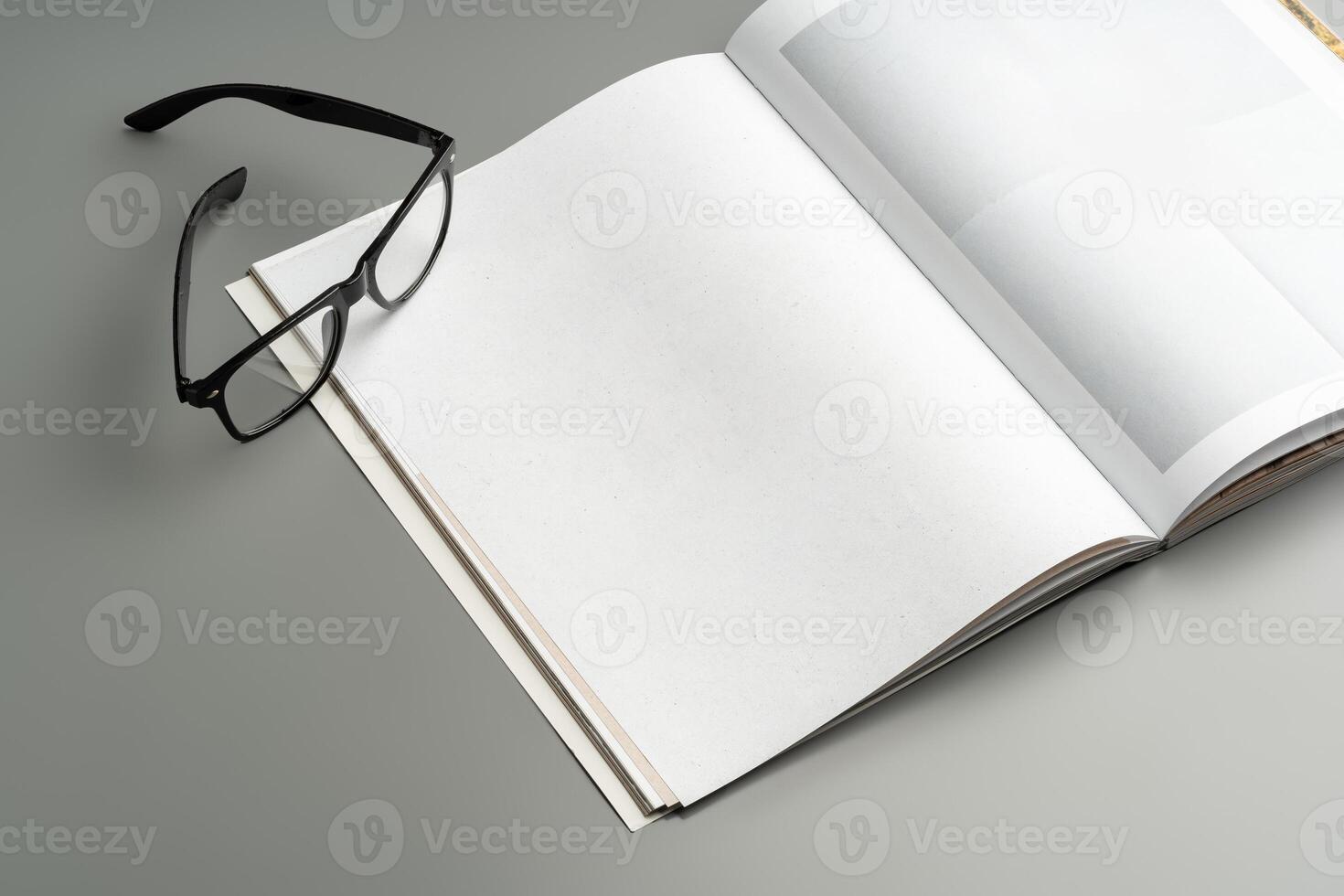A blank open notebook resting on a neutral background during daylight photo
