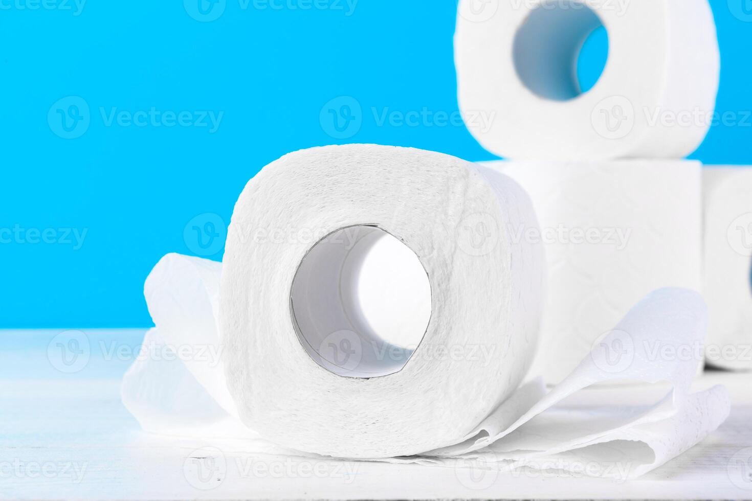 Toilet paper rolls stacked against blue background photo