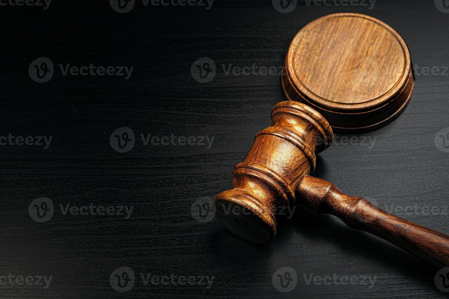 Judge's gavel on wooden table in dark photo