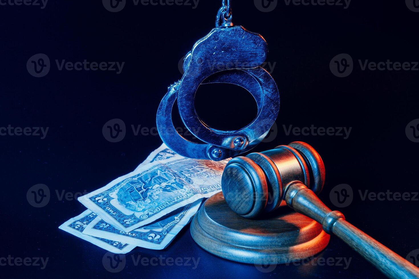 Bribe concept. Dollar banknotes, handcuffs and gavel on dark black table photo