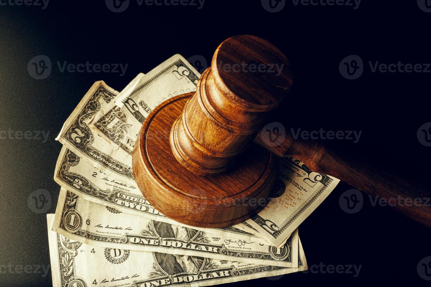 Wooden judge gavel on US dollar banknotes closeup. Justice corruption concept photo