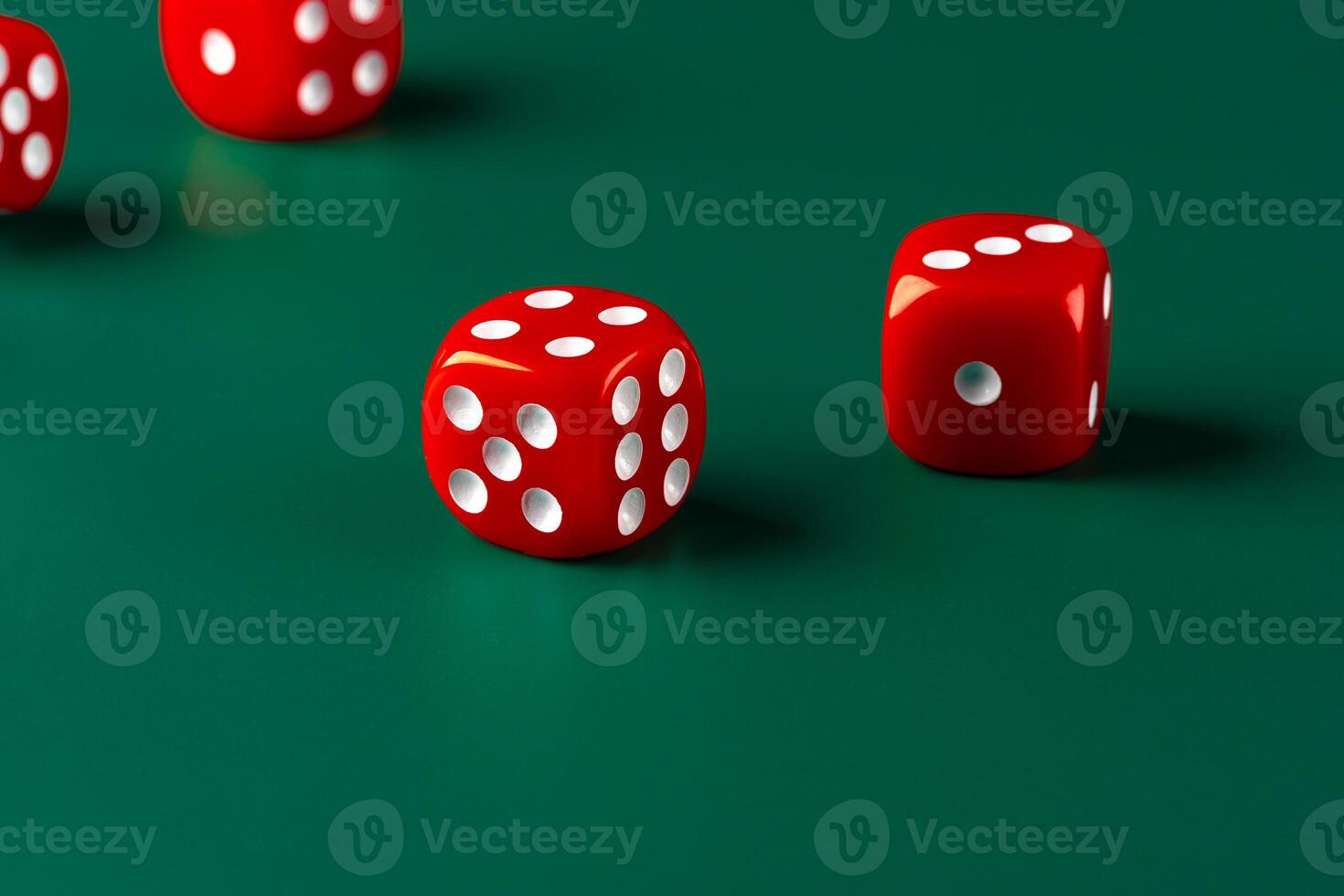 Red dice on green background close up photo