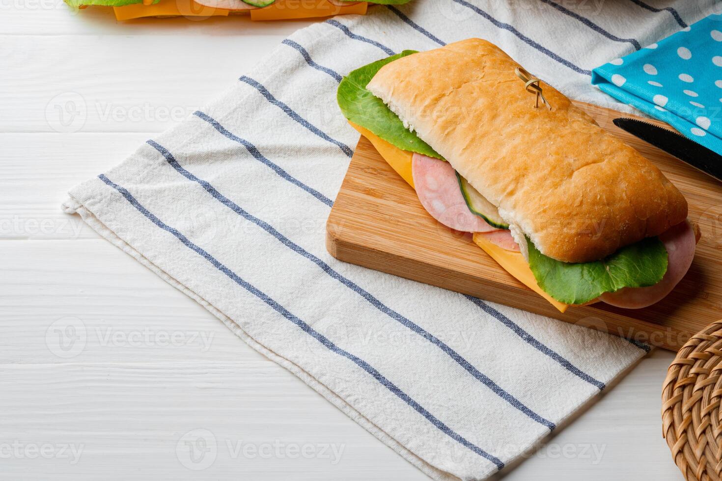 Fresh sandwich with sausage and lettuce on table photo