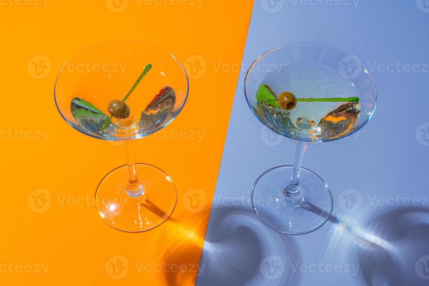 Two classic dry martini with olives on color background. photo