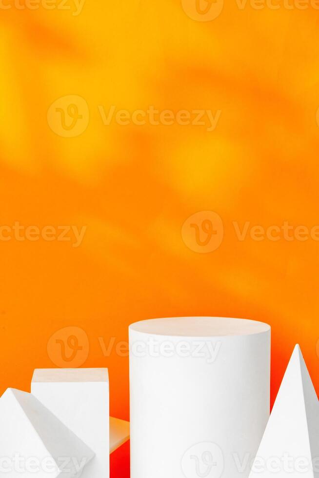 White geometric shapes on a vibrant orange background with soft shadows in a well-lit indoor setting photo