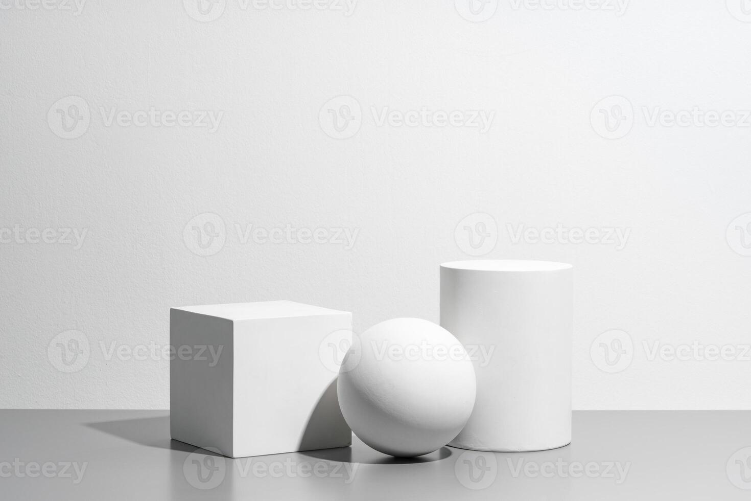 Abstract composition featuring three white geometric shapes in a minimalist interior setting photo