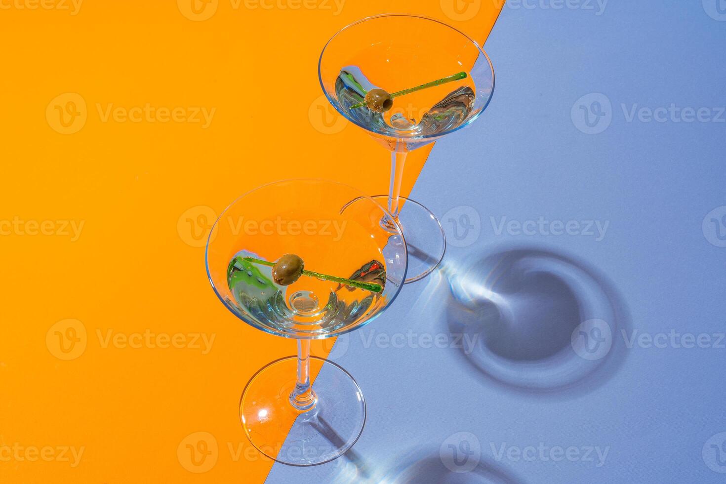 Two classic dry martini with olives on color background. photo