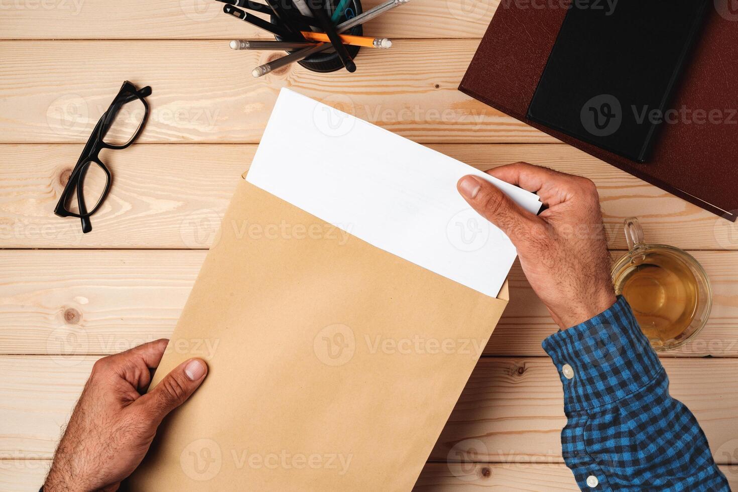 Business correspondence. Top view of man hands holding mockup envelope with letter. Copy space. photo