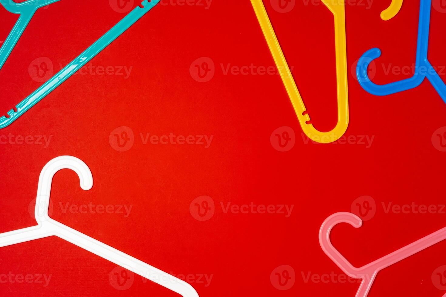 Hanger on red paper background. Minimalistic fashion concept. Top view photo